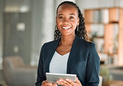 Smiling woman holding tablet in office
