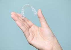 Closeup of patient holding clear aligner