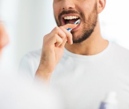 Man brushing teeth to prevent dental emergencies