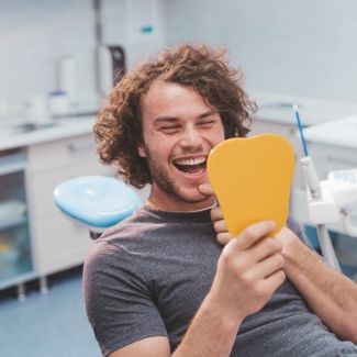 Man looking at smile during preventive dentistry visit