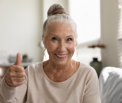 Smiling dental patient giving thumbs up