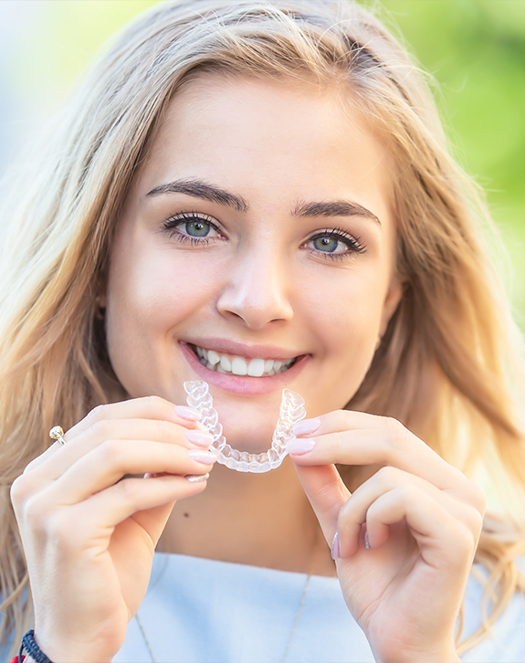 Young woman placing clear braces orthodontics aligner