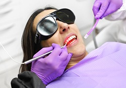 Dentist applying in-office whitening to patient’s smile