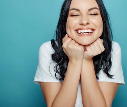 Woman smiling brightly on blue background