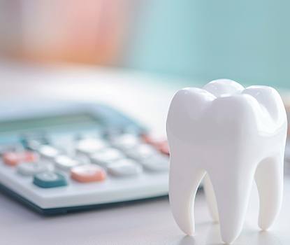 Model tooth next to calculator